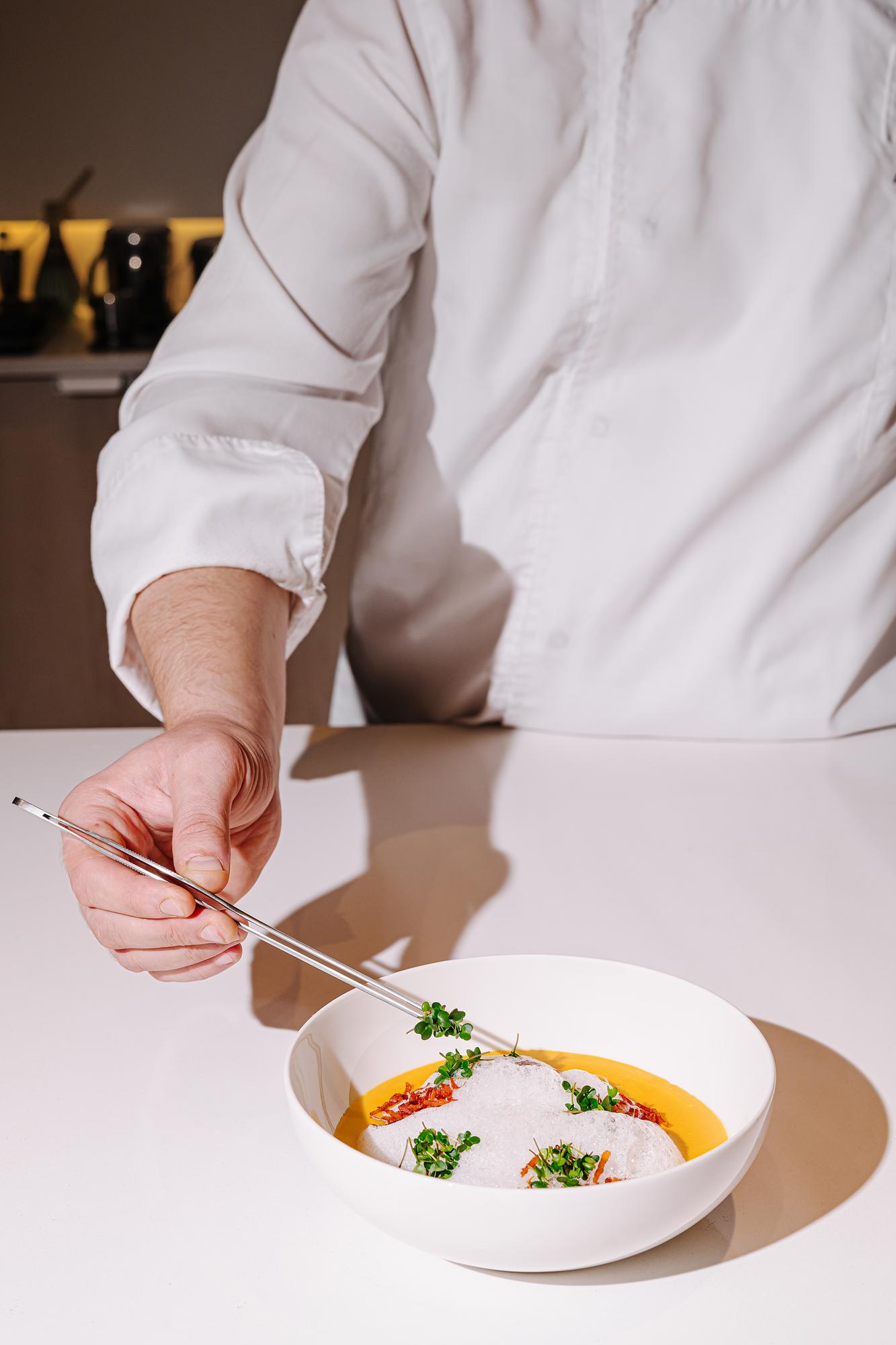 Szef kuchni przygotowuje talerz fine dining